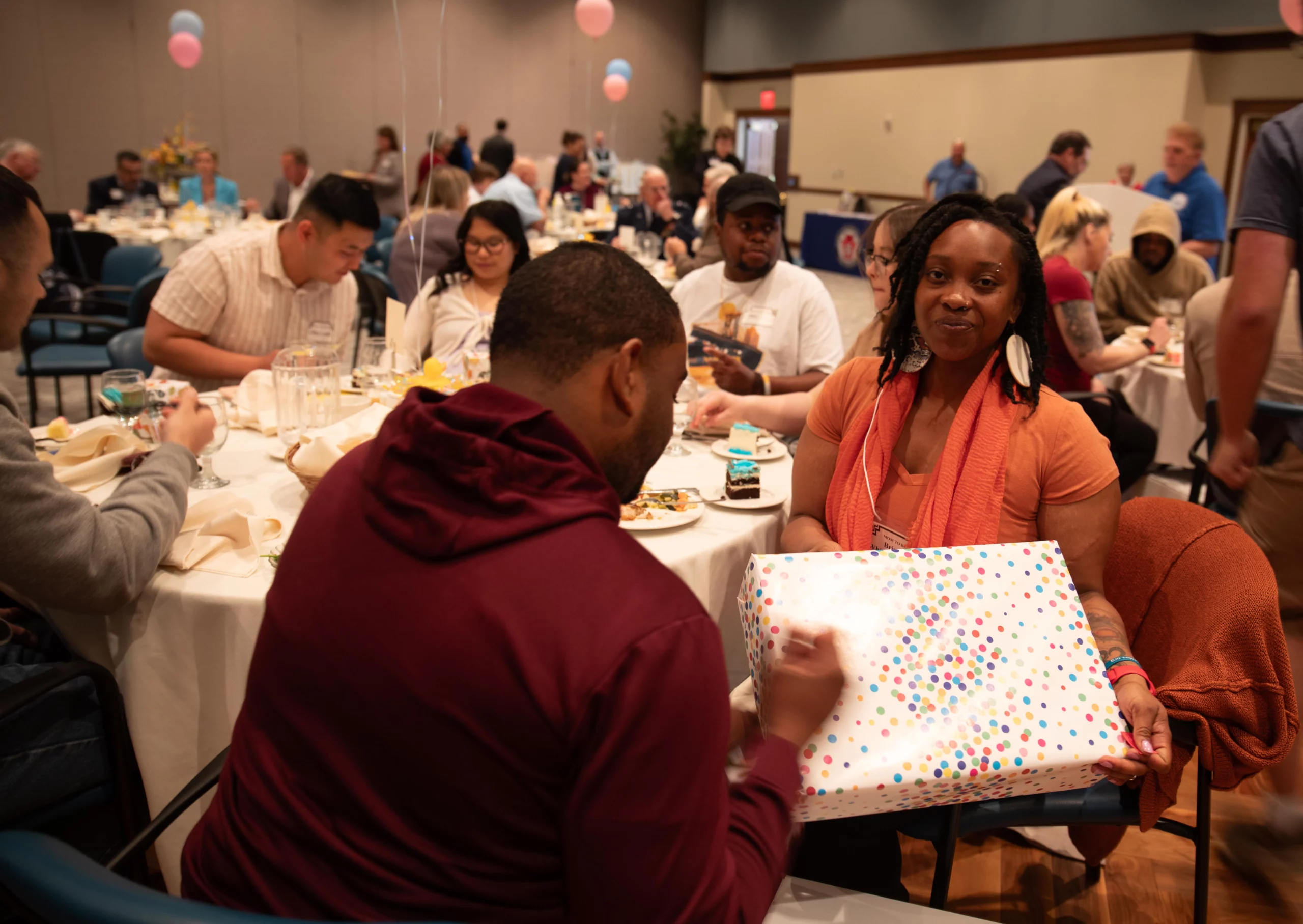 Closeup of family opening gift together.