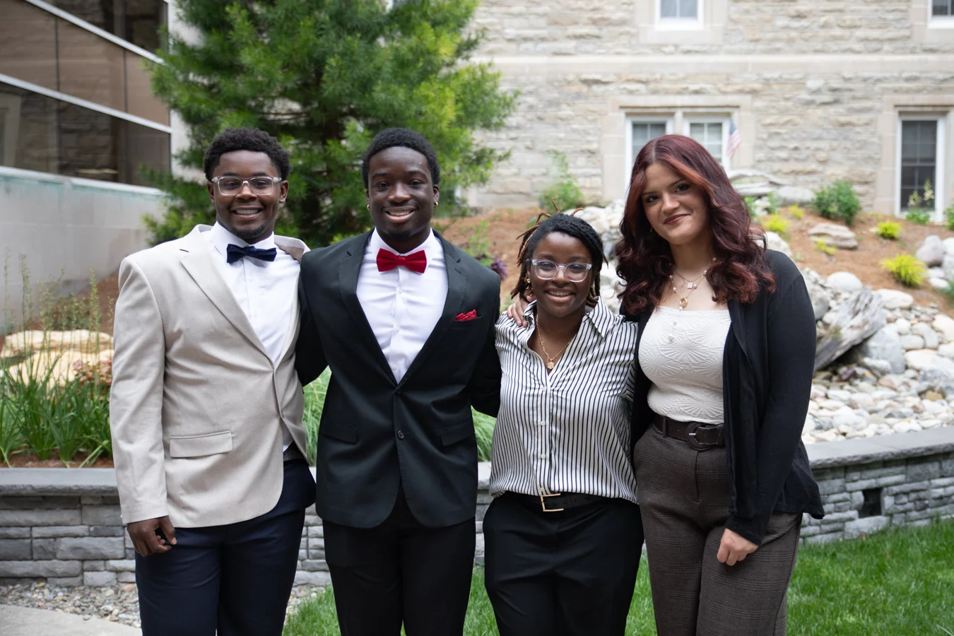 Group of smiling teens in formal attire.