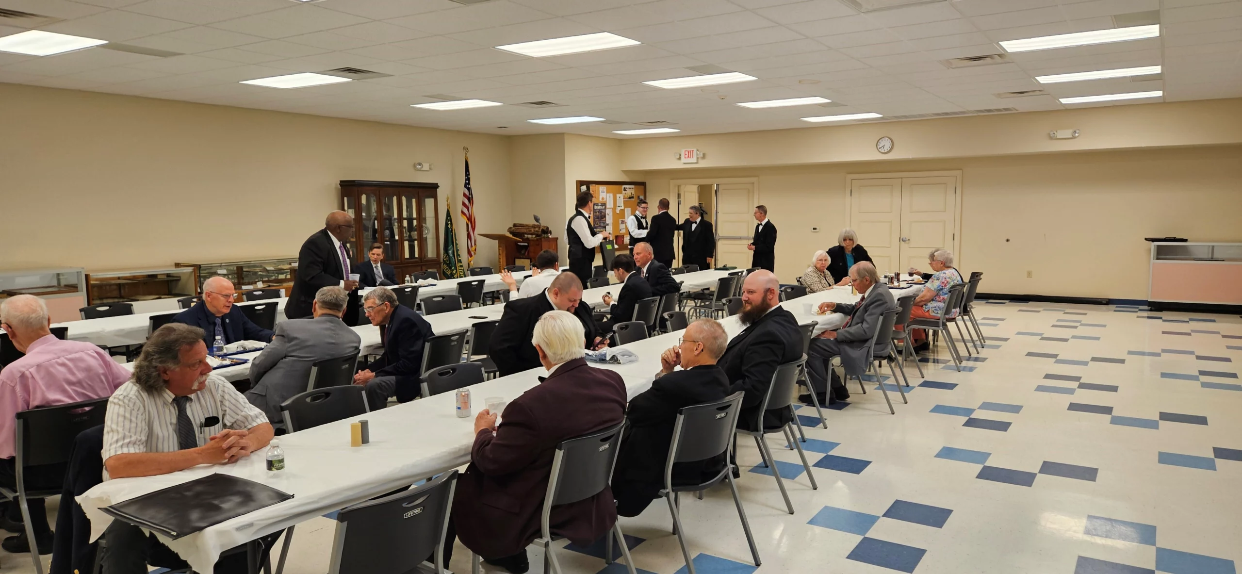 Masons sitting at long tables together.