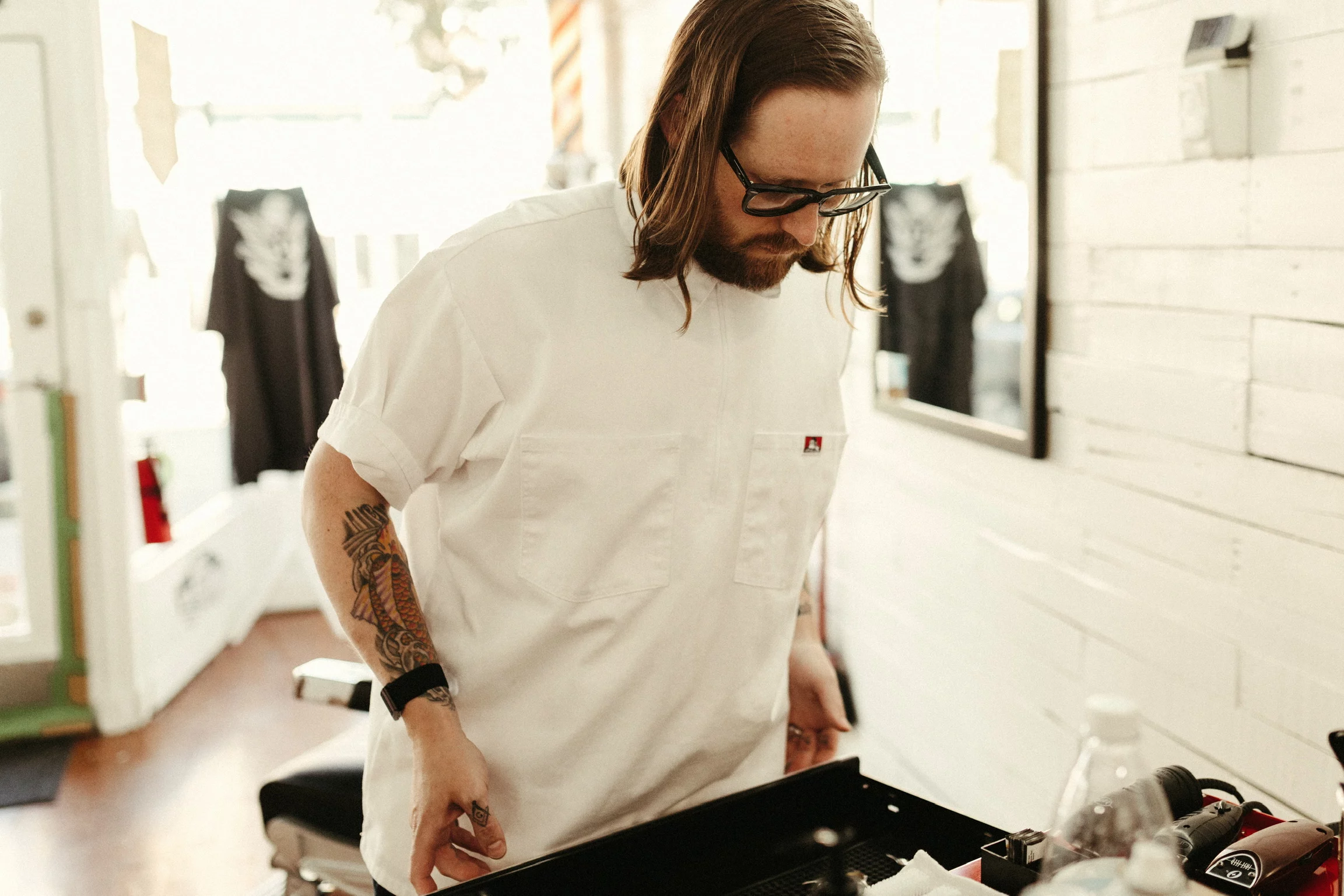 Nate Storck 2 Man dressed in black and white working in his barber shop.