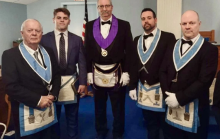 Group of Masons standing together in lodge room.