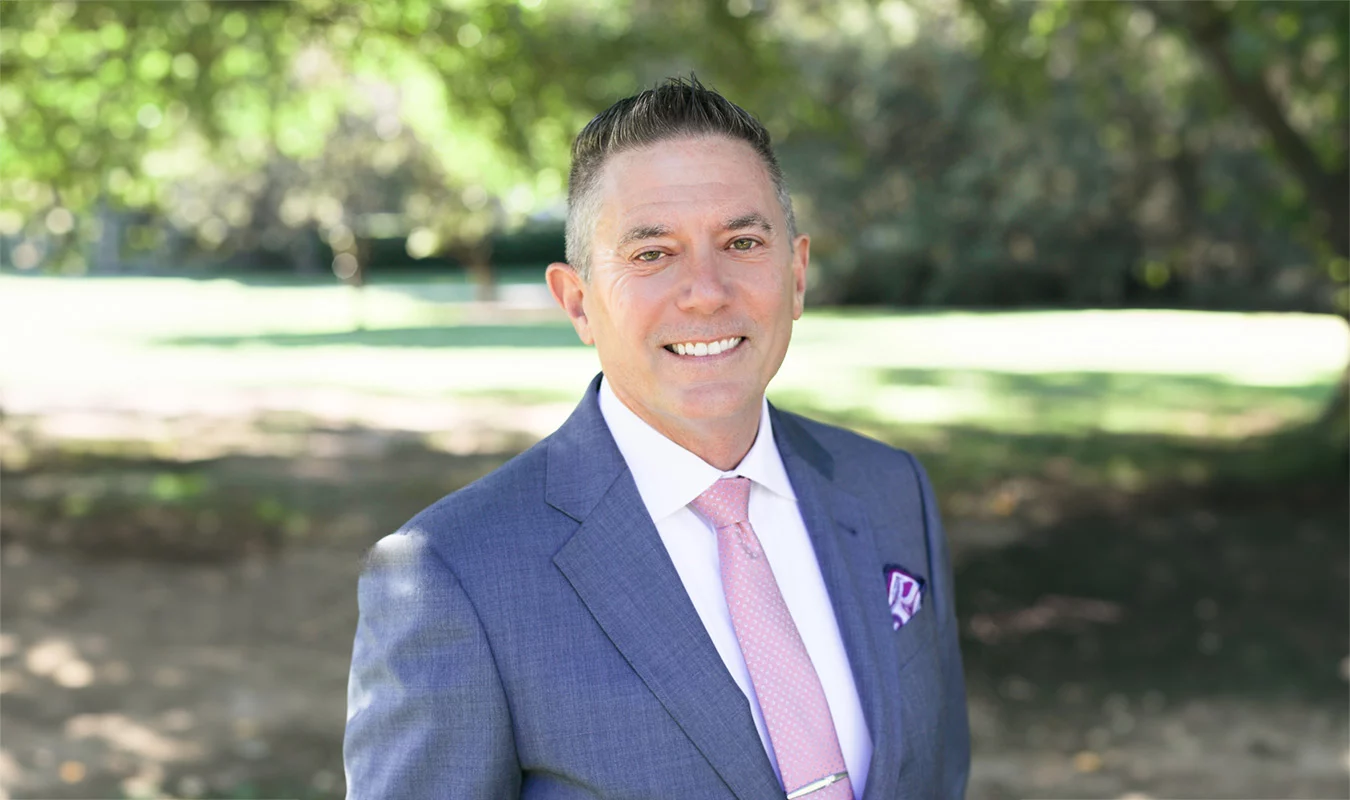 2V9A92242 Smiling man dressed in suit outdoors.