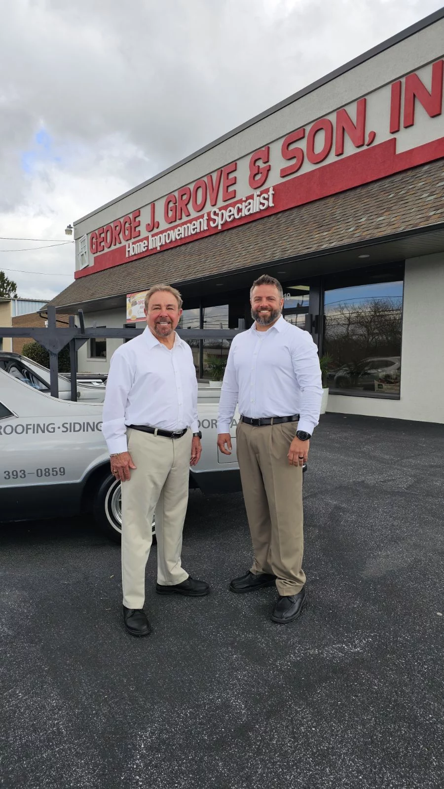 Two smiling men outside of construction business.