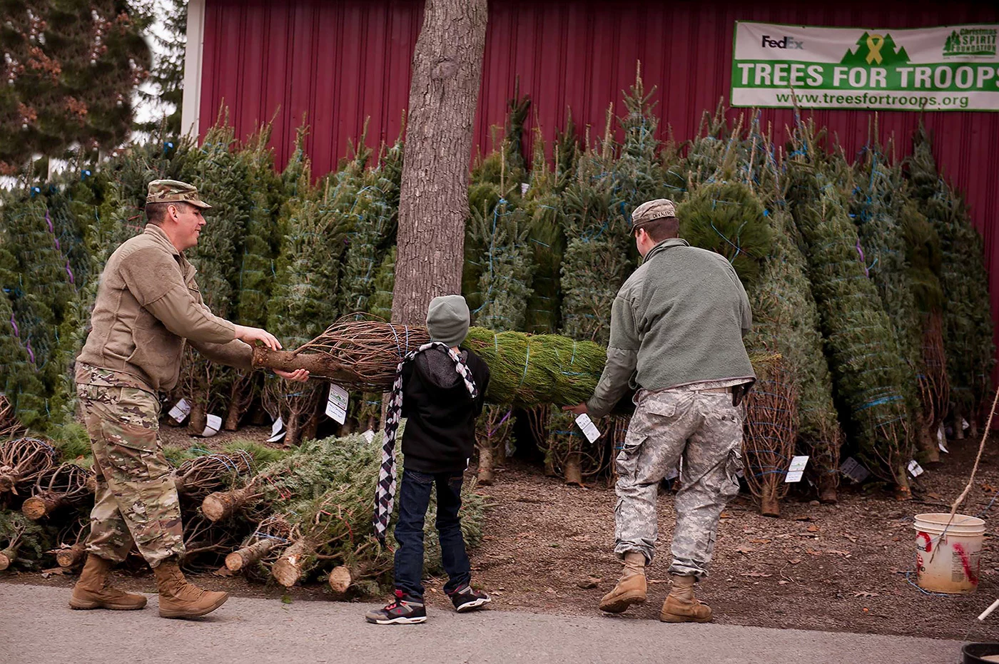 15625798_1865270867022733_8017473894743987947_o Men in military uniform and a boy lifting evergreen tree.