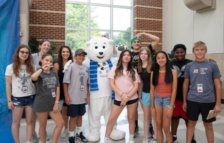 2V9A1814-Edit Group of smiling children with bear mascot.