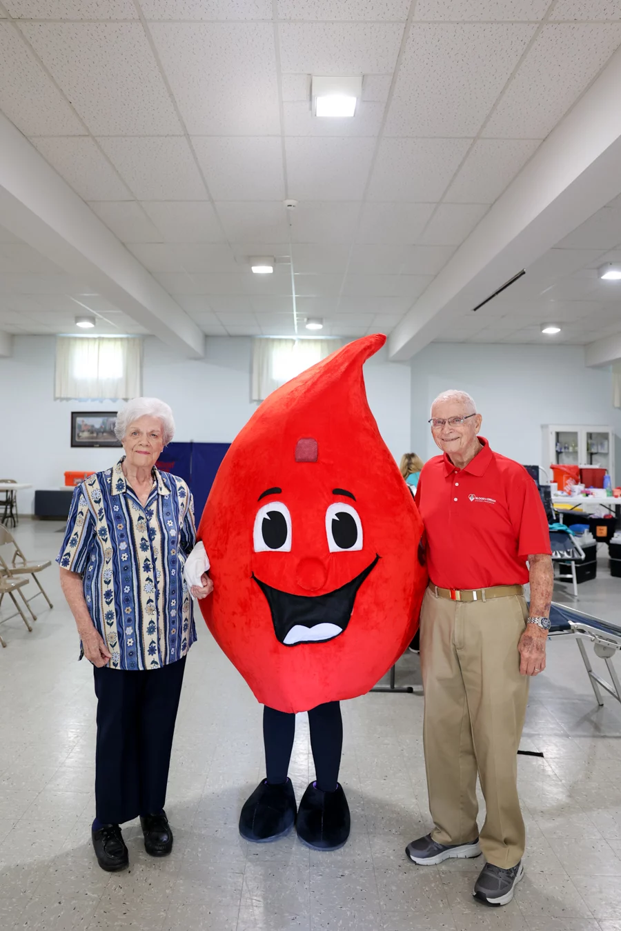 Couple standing next to blood drop character.