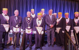Group of smiling men dressed in Masonic regalia.