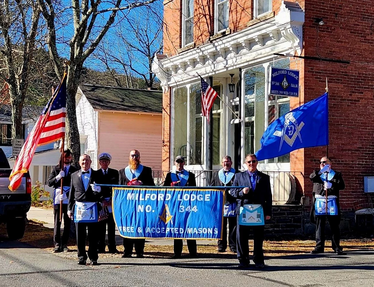 Group of men holding Milford Lodge banner for parade.