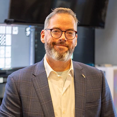 9I4A8121 Smiling man with short hair and glasses.