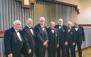 Group of smiling men in tuxedos.