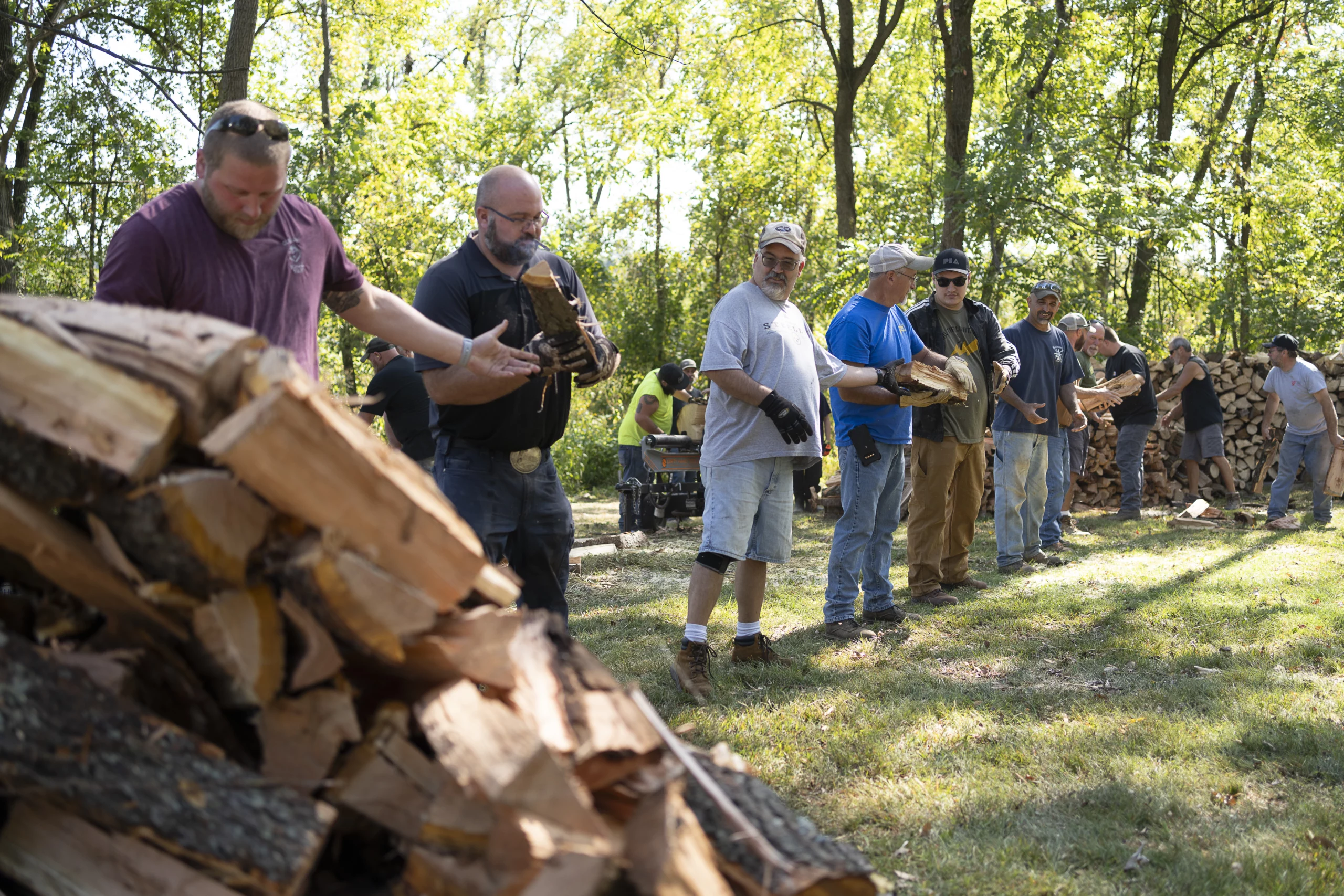 Group of men chopping and stacking wood.