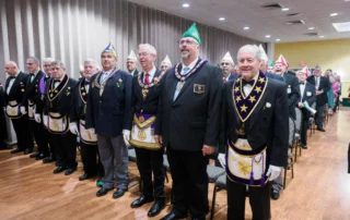 Large group of men in Masonic dress and standing.