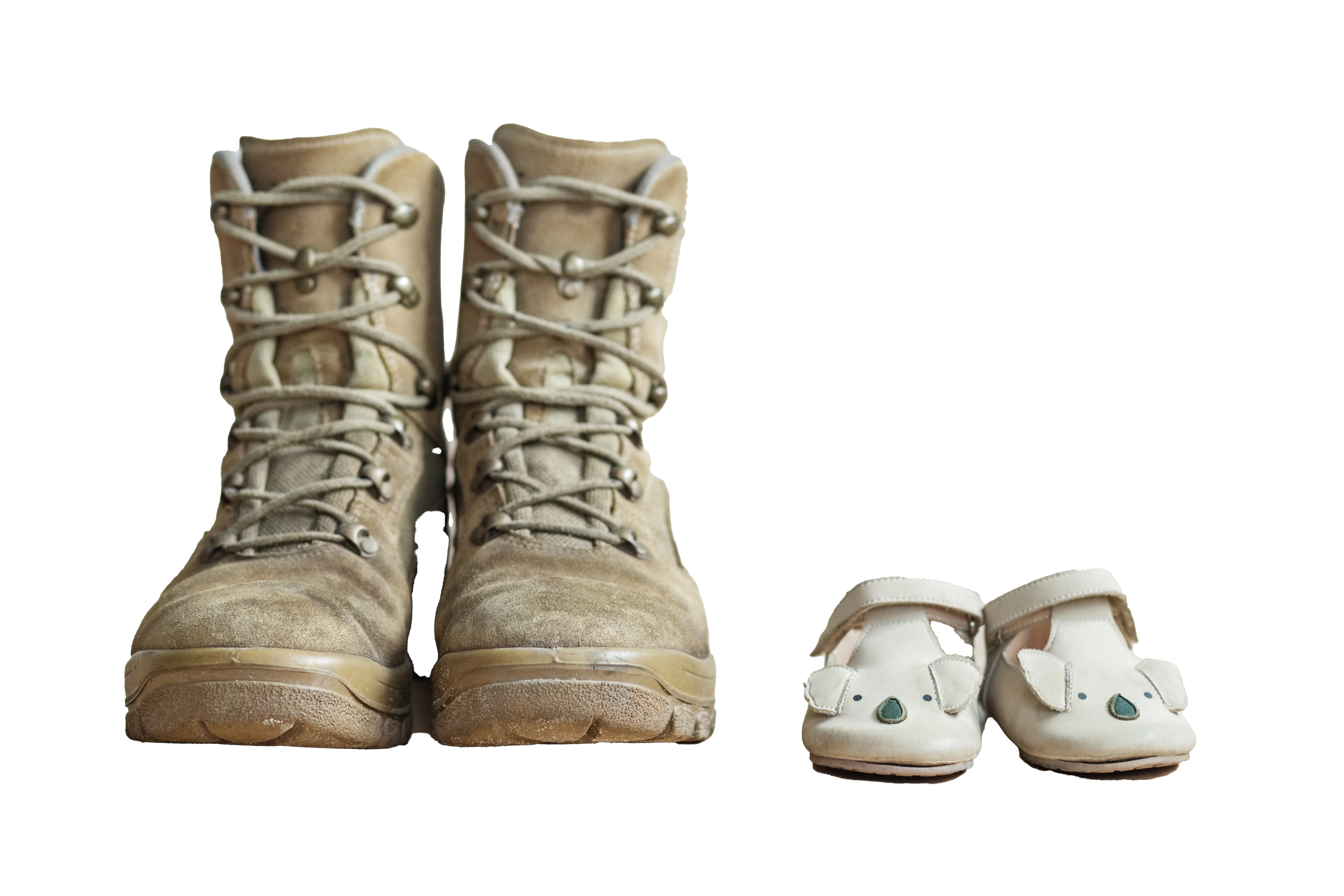 Closeup of military boots and children's shoes.