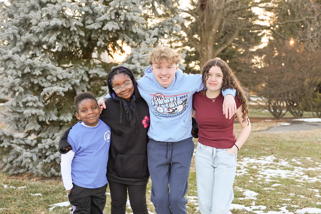Group of smiling kids standing together outdoors.