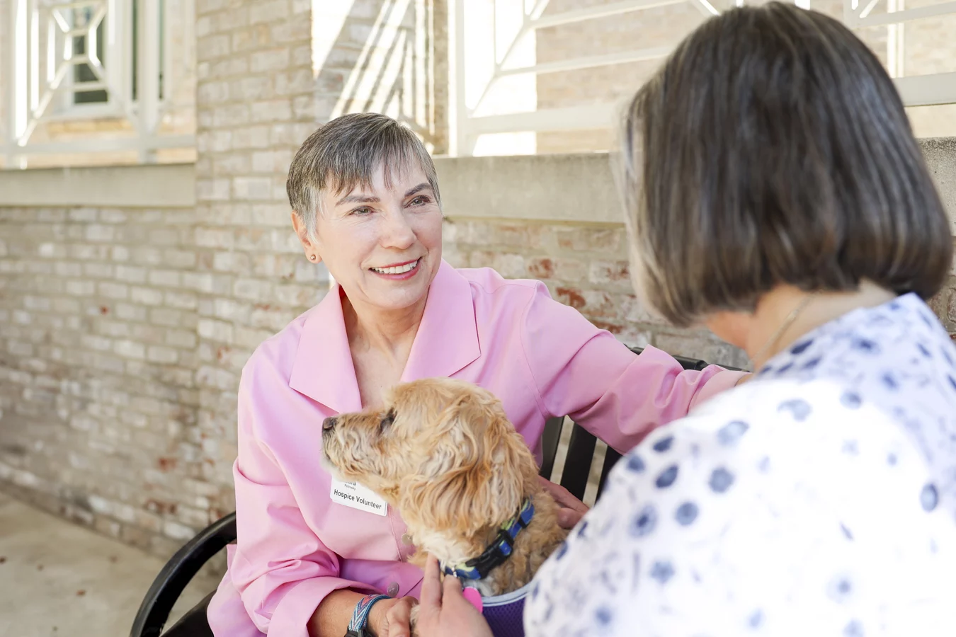 Woman with smiling hospice volunteer and dog.