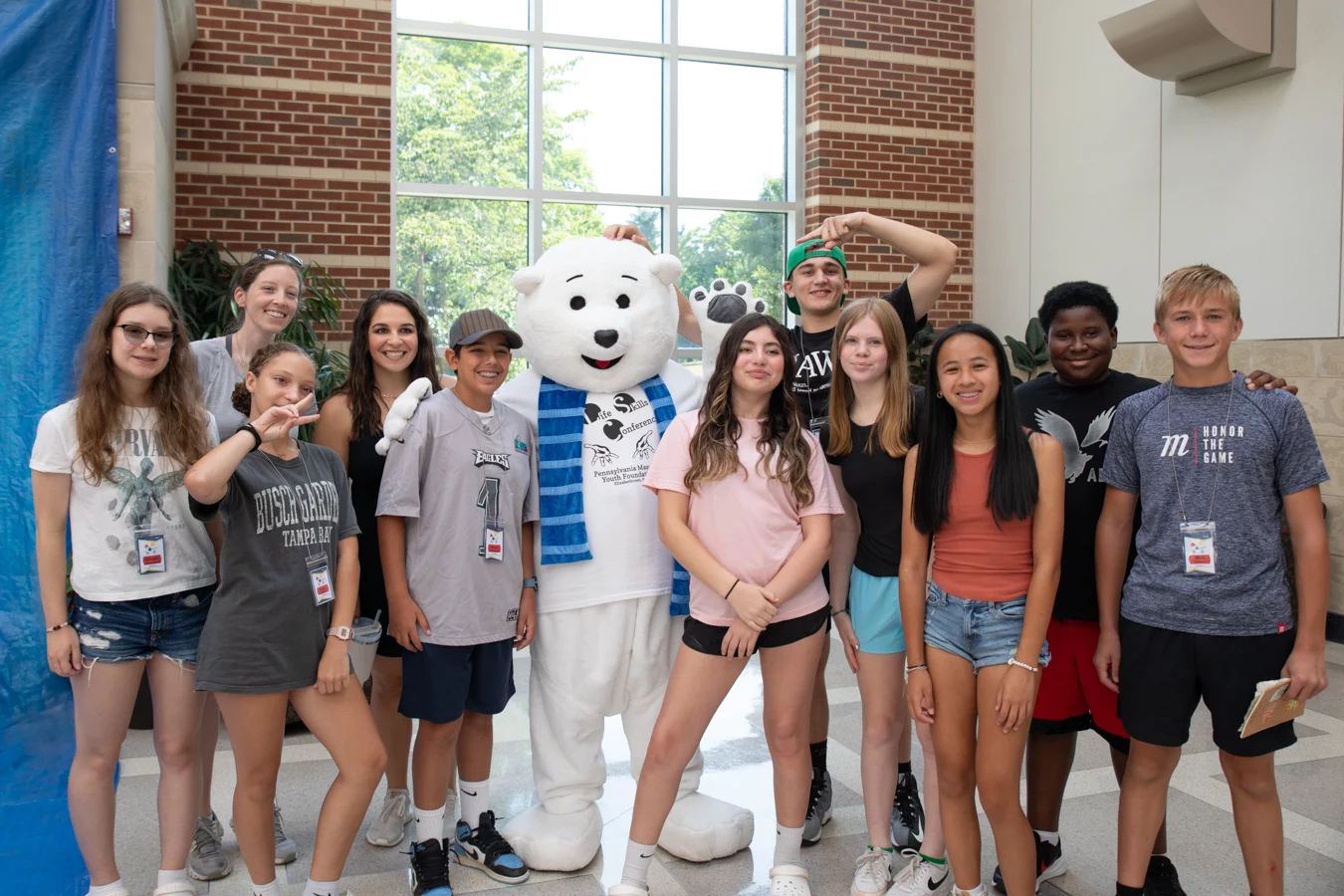 Group of smiling kids with polar bear mascot.