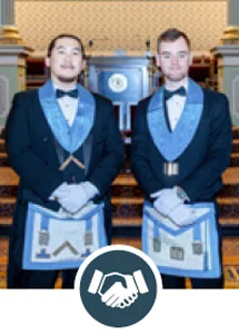 Young men standing together in Masonic dress with icon of two hands shaking.