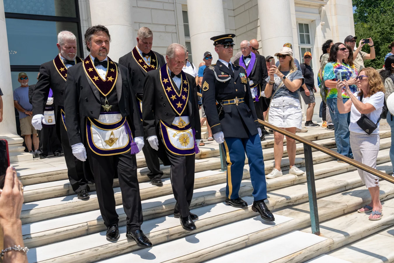 DSC07426_edited Grand Lodge officers in masonic dress walking with man in military uniform down stairs at the Tomb of the Unknown Soldier.