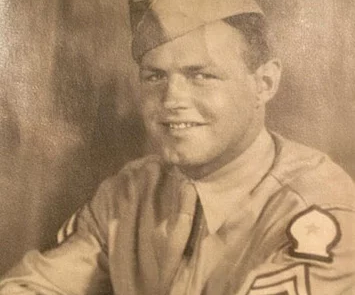 Aged photo of smiling man in military uniform.