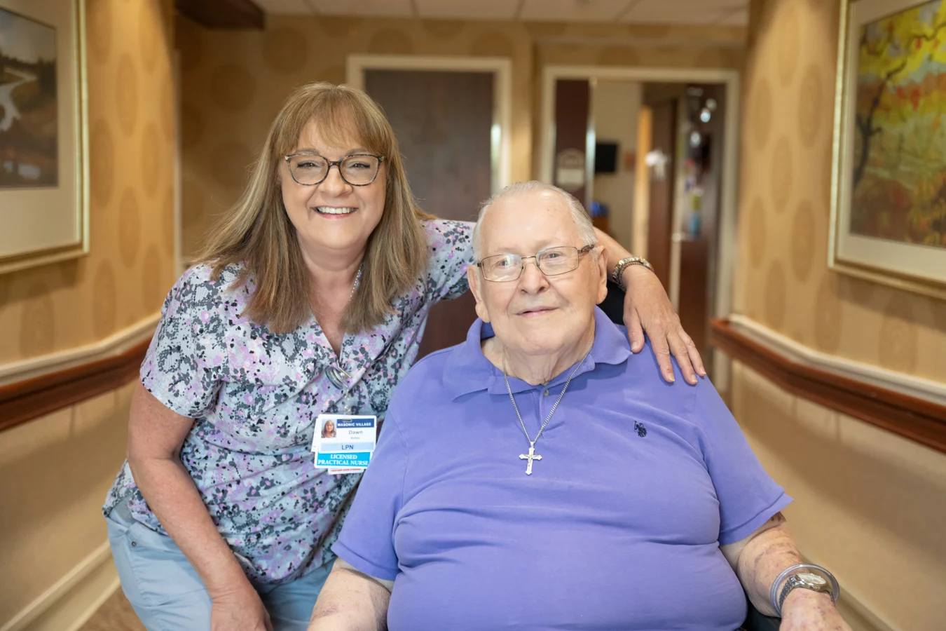 Nurse and man sitting in hall together.