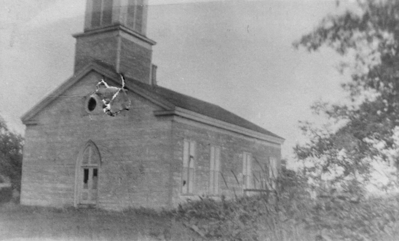 641fda13-d7a7-43d2-8632-f45209f64af0 Aged black and white photo showing exterior of building.