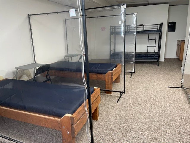 Beds lined up indoors with dividers.
