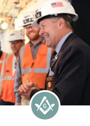 Smiling men with construction helmets with Square and Compass icon.