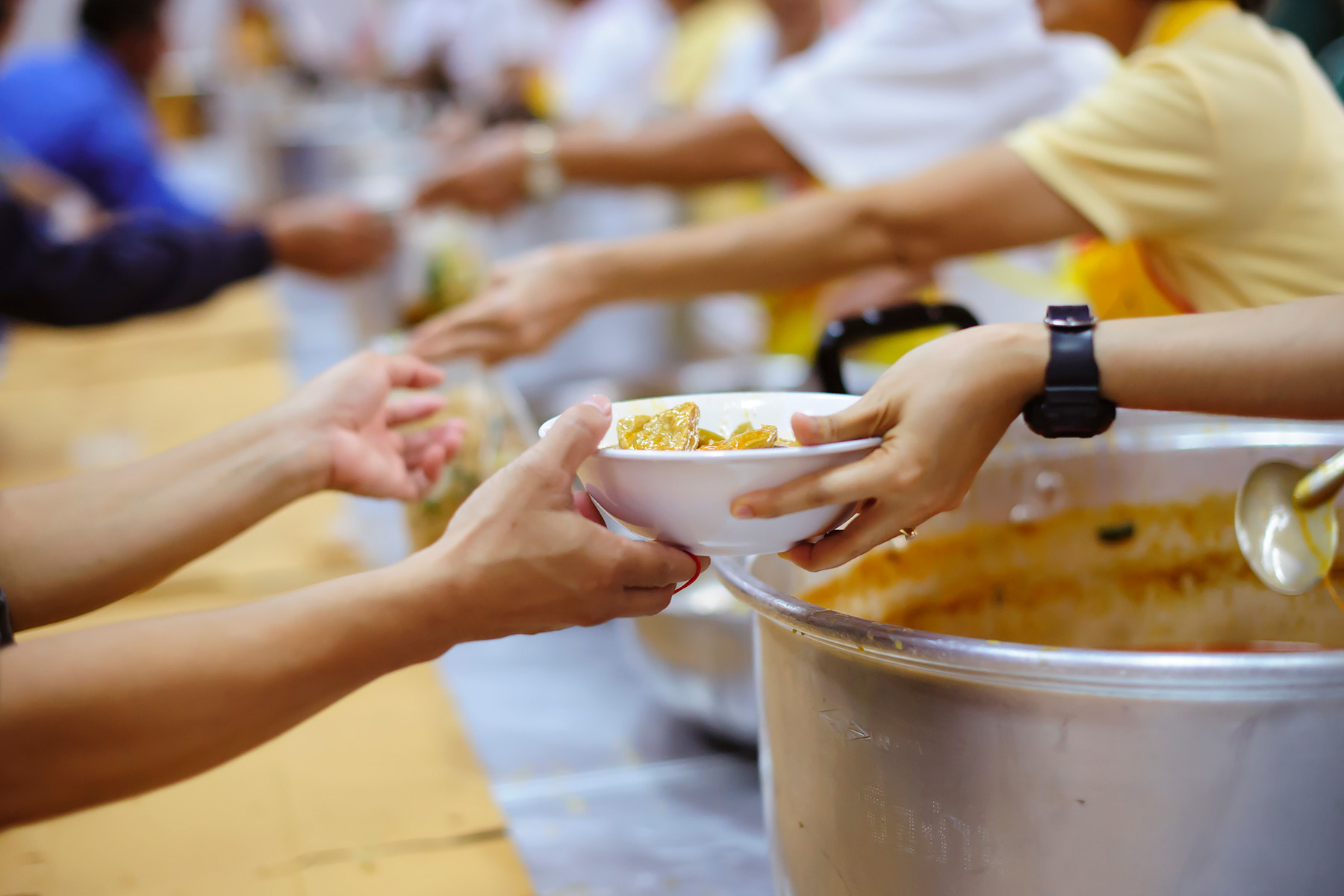 Closeup of volunteers handing out food