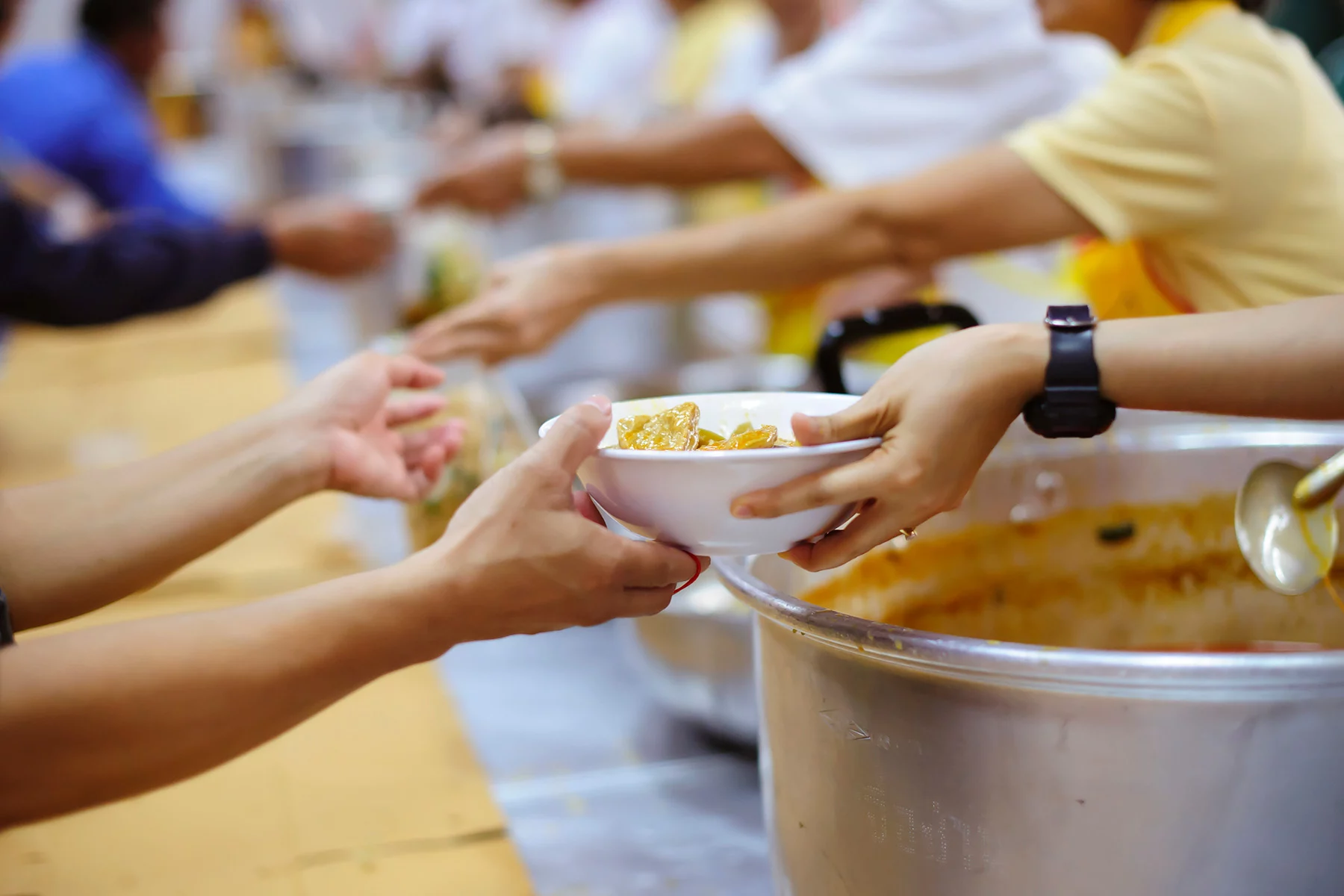 Closeup of volunteers handing out food.