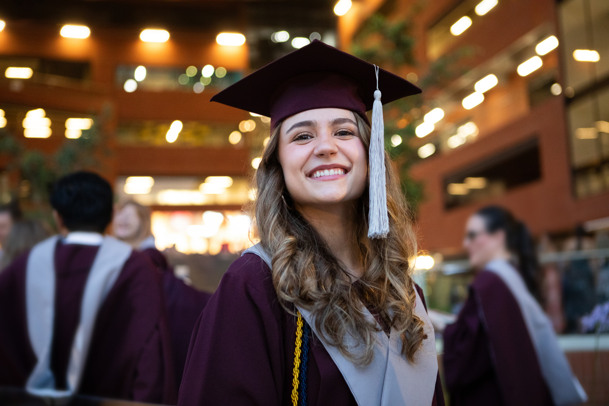 Young woman in graduation cap and robe