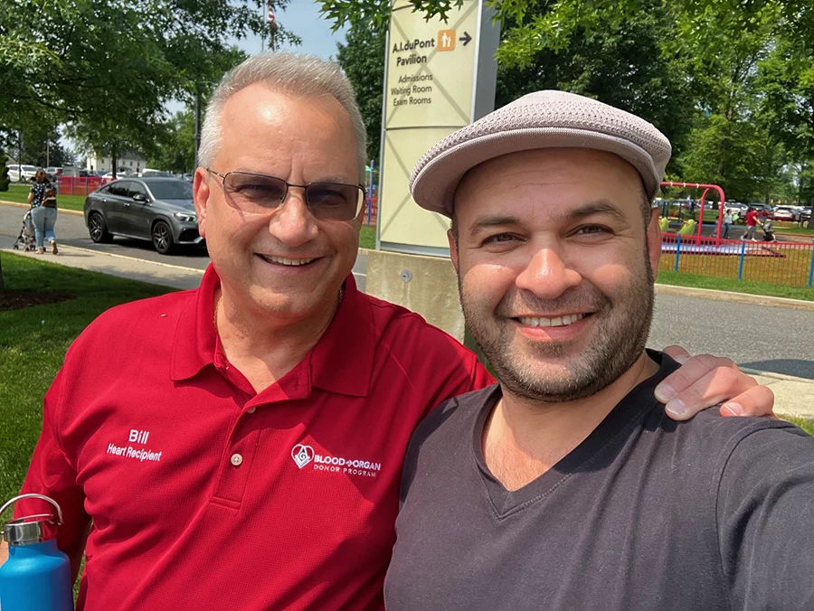 Two men together smiling outdoors.