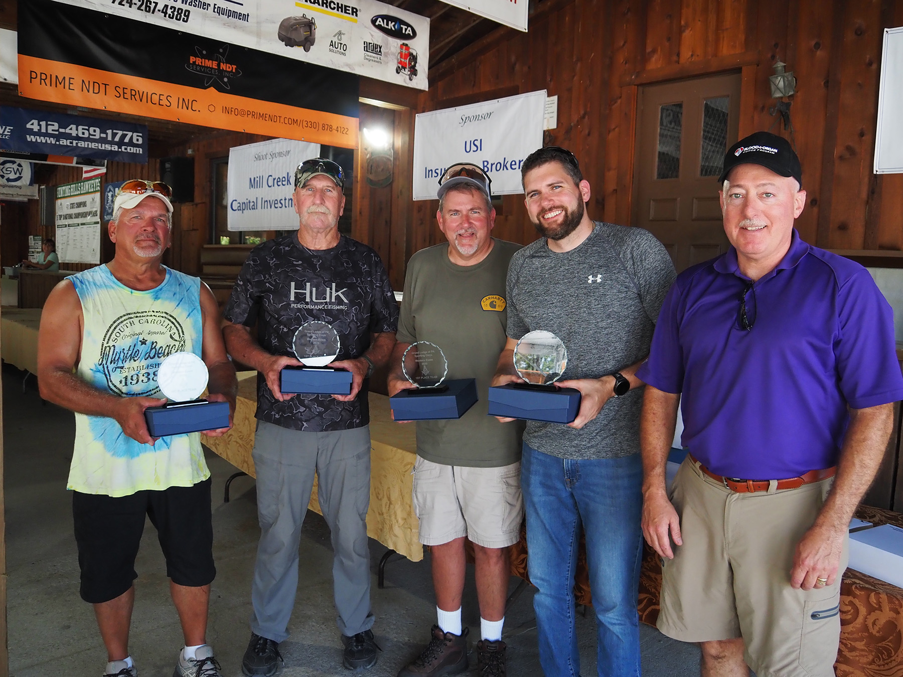 Group of men holding trophies standing with Deputy Grand Master Larry Brink