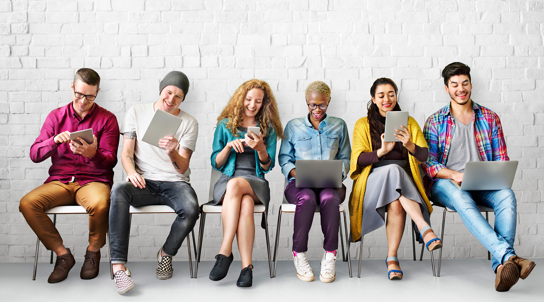 Group of young adults on electronic devices