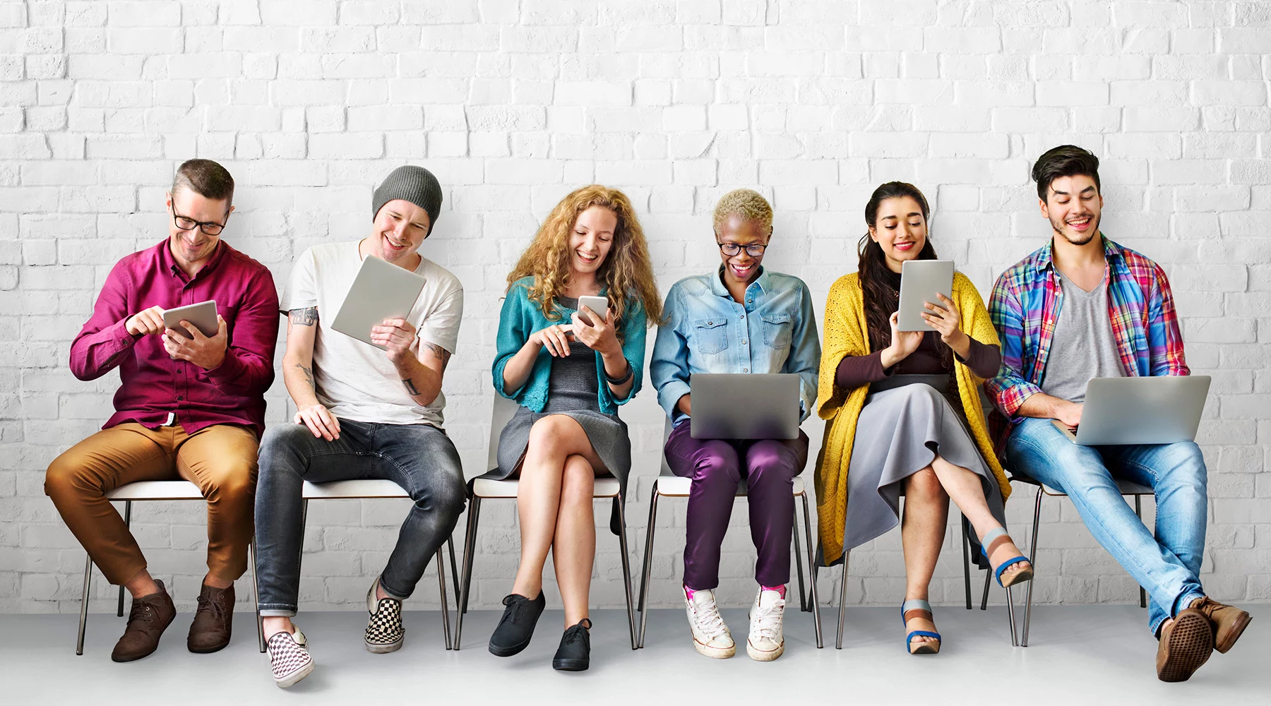 Group of young adults on electronic devices.