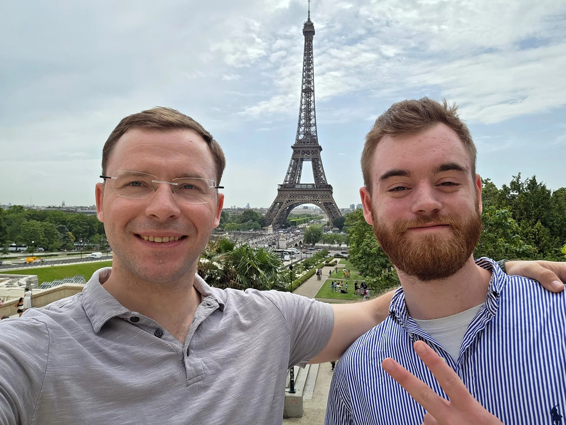 Two men smiling with Eiffel Tower in the background.