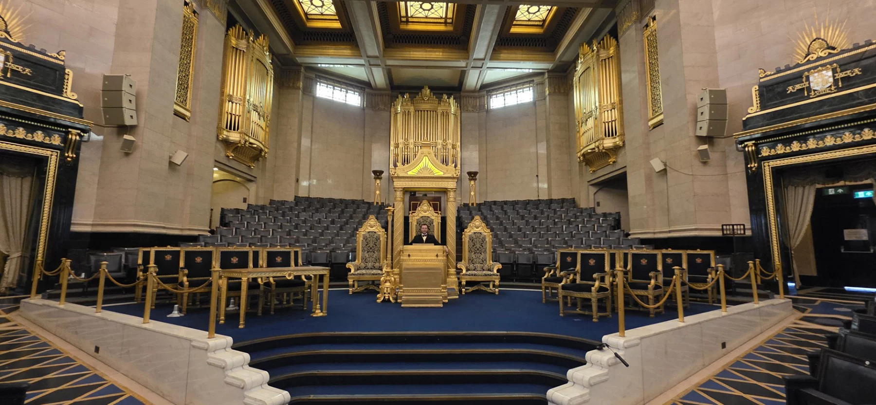 spencerandchris3 Ornate lodge room with man sitting in a chair at the center.