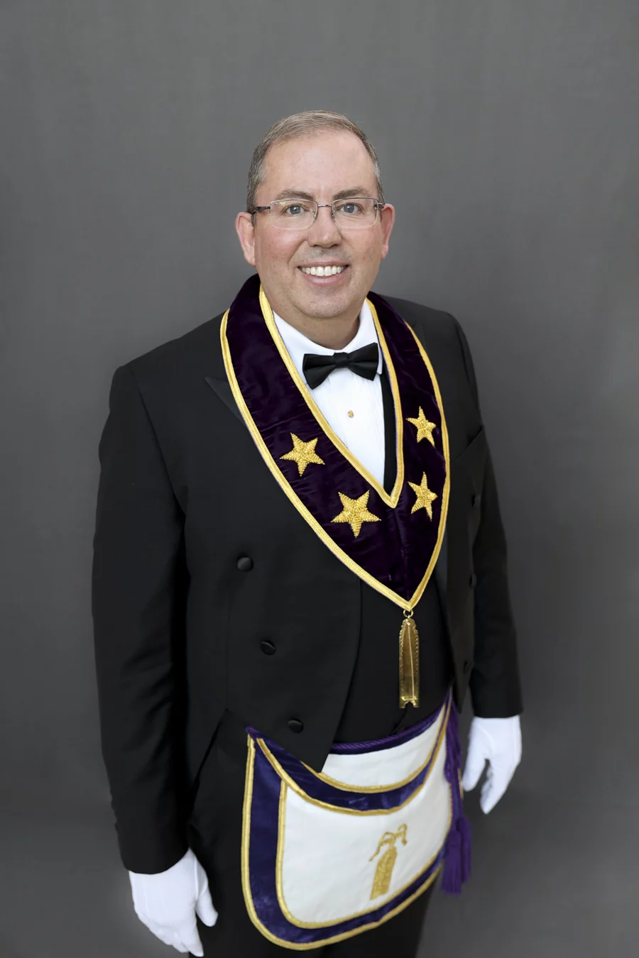 1W8A4832-Edit-Edit Smiling man with glasses dressed in Masonic Grand Lodge Officer attire.