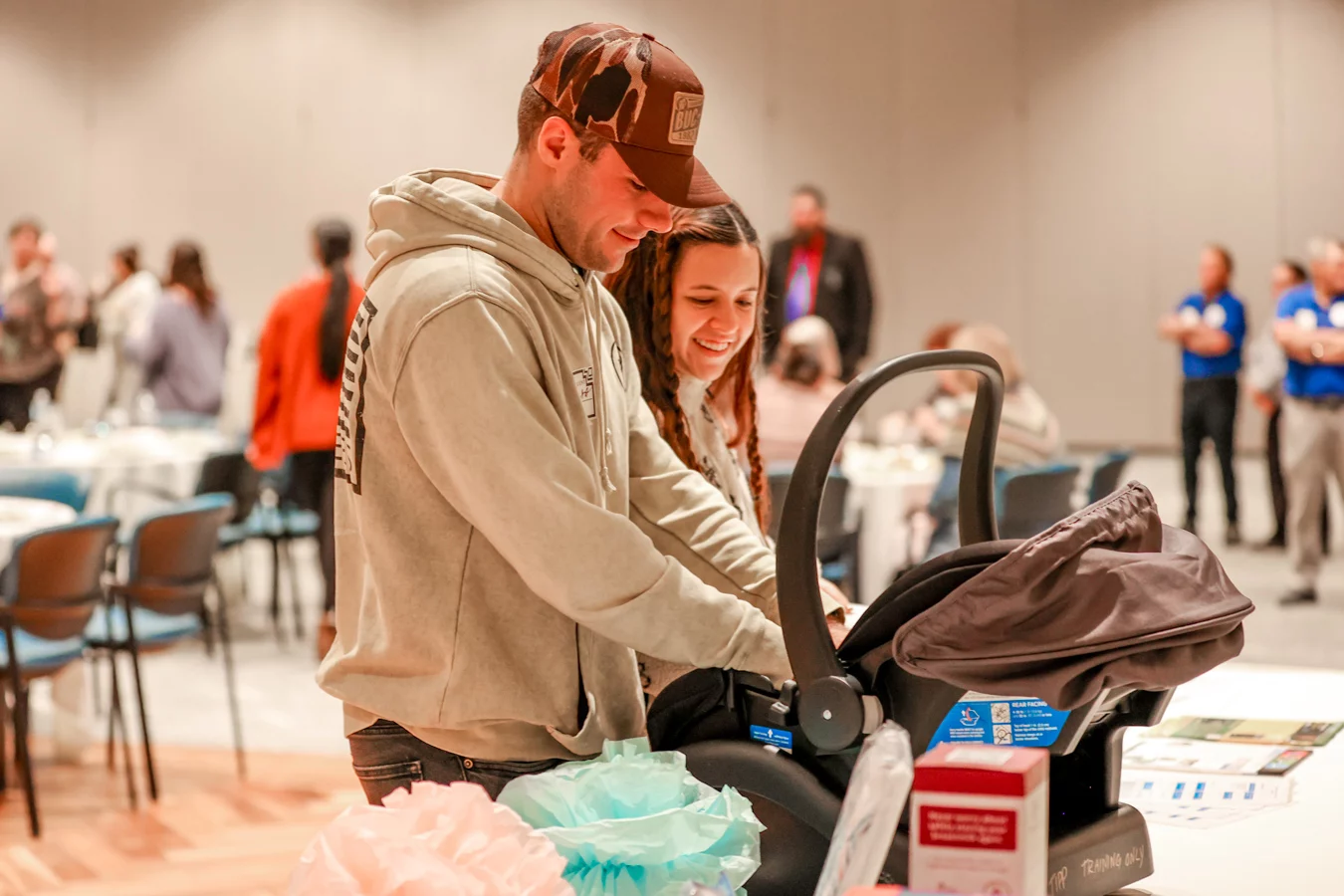 1W8A4884 Couple smiling while unpacking baby car seat.