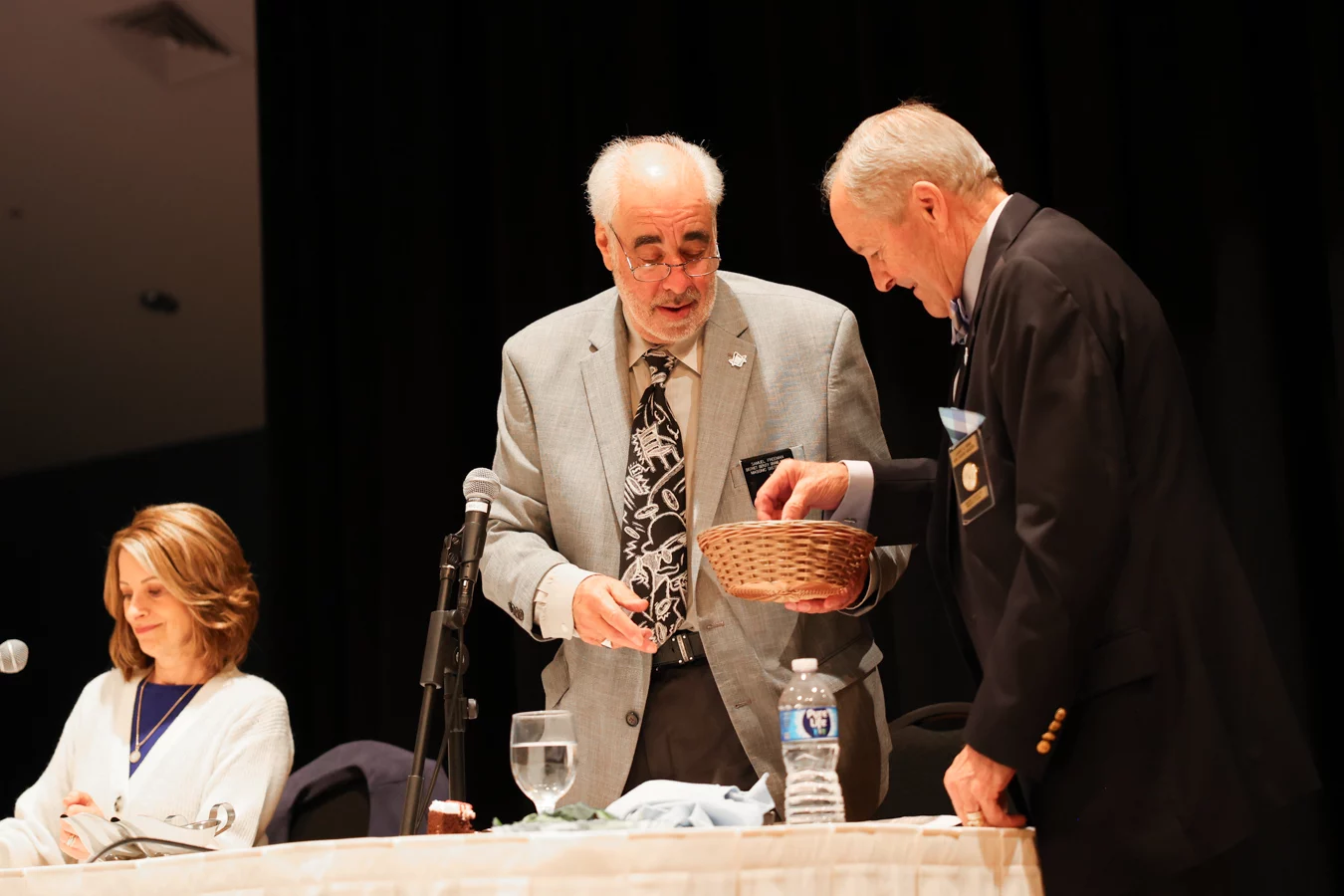 1W8A5038 Grand Master Larry Derr reaching into basket held by another man.