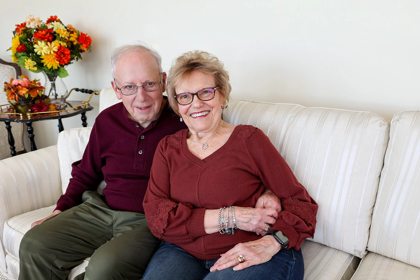Smiling couple seated on couch together.