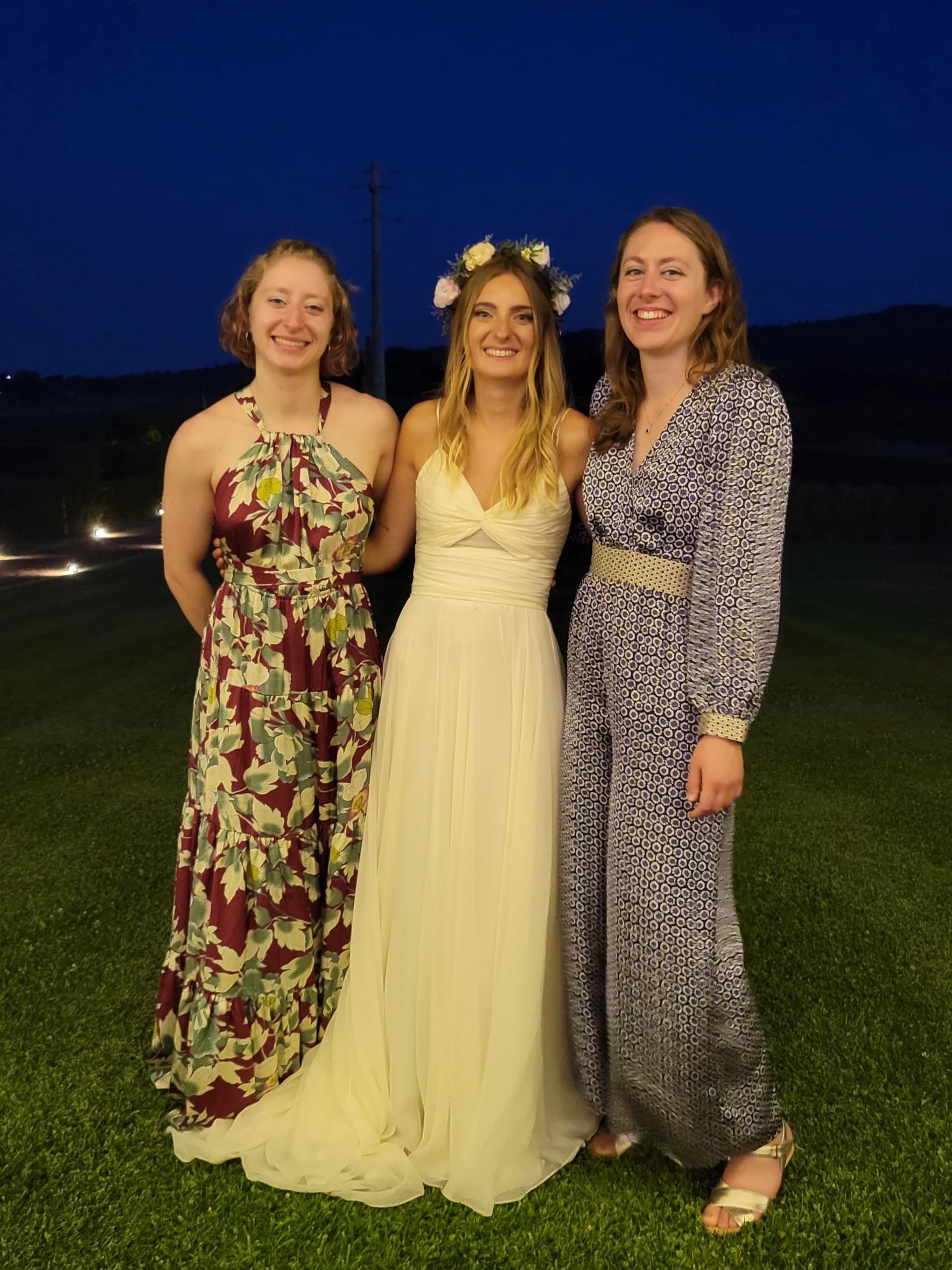 Three young women posed together in formal attire.