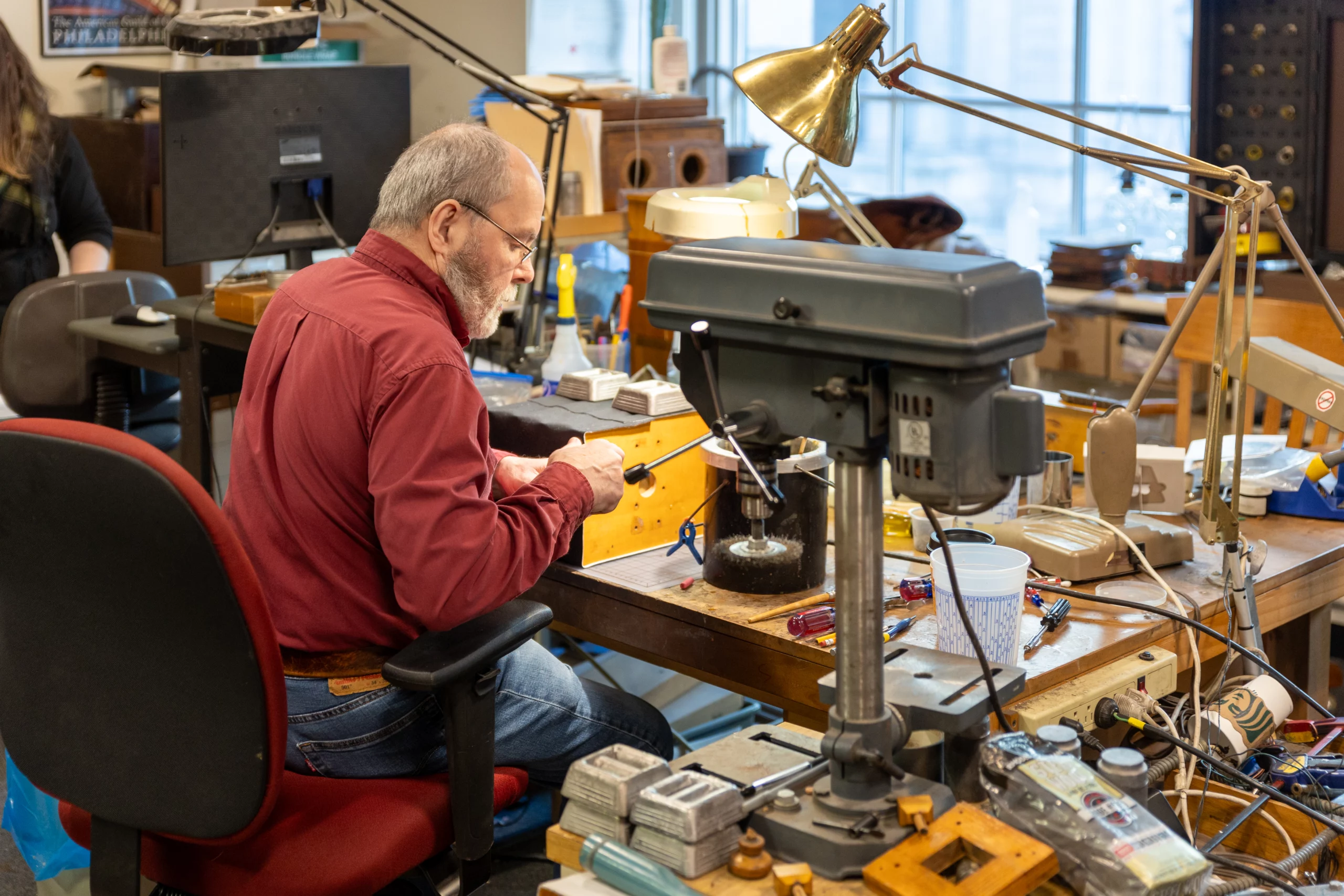 9I4A1196 Man working at desk surrounded by equipment.