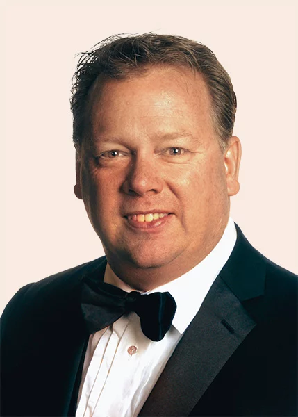 Smiling man with short dark hair, wearing suit and bow tie.