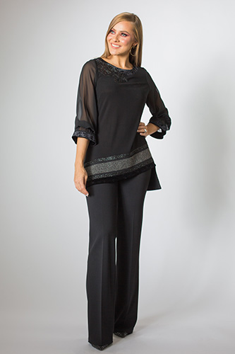 Smiling woman with black dress pants and shirt.