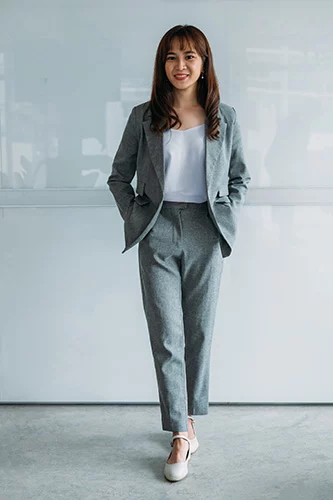 Woman in grey blazer and pants.