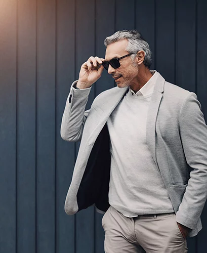 Man in collared shirt, blazer and tan pants.