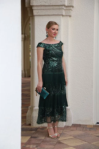 Woman in full-length green dress and silver heels.