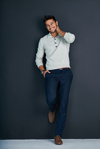 Smiling man in collared shirt and dark blue pants.