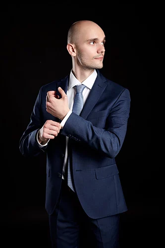 Man dressed in dark suit and tie.