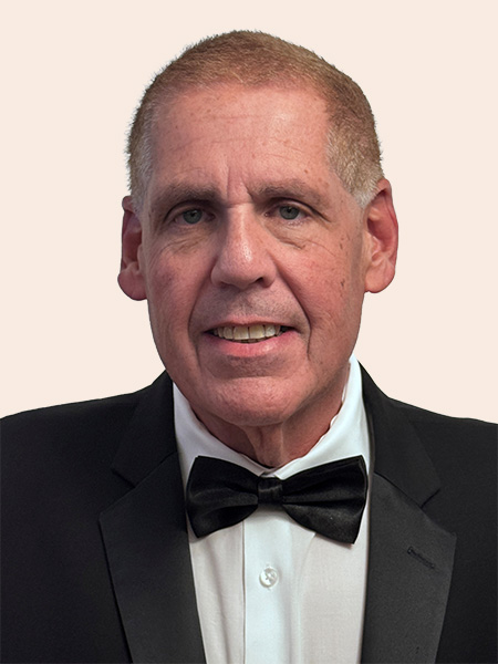 Howard L Glickman GC_nobackground Smiling man with short hair wearing suit and bowtie.